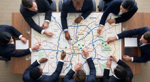 A team of professionals placing markers on a printed map of the metro area, planning a localized Atlanta law firm SEO campaign