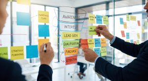 "Professionals mapping out a marketing conversion funnel with sticky notes on a glass wall, illustrating CRO strategies for PPC Alpharetta."